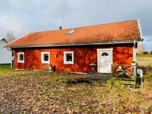 奈舍Ruth & Iris Cottage的田野上一扇白色门的红色房子