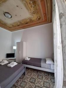 巴勒莫Sant'Oliva28的客房设有两张床和天花板。
