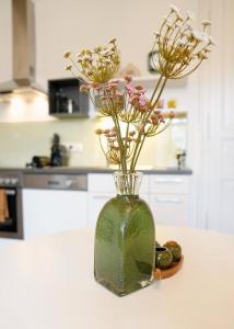 格拉茨Stilvolles Apartment in zentraler Lage的厨房里的柜台上装有鲜花的花瓶