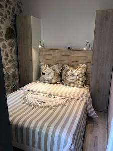 昂蒂布Vieil Antibes, ravissant 2p avec petite terrasse的床上有条纹毯子和枕头