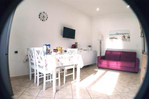布林迪西Chiara's Home的客厅配有桌子和紫色沙发