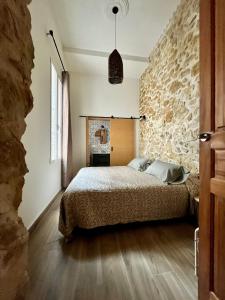 阿利坎特Casa del Pasaje San Fernando的一间卧室设有一张床和石墙