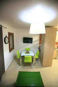德尼亚Ca Isaak的一间带桌子和绿色椅子的用餐室