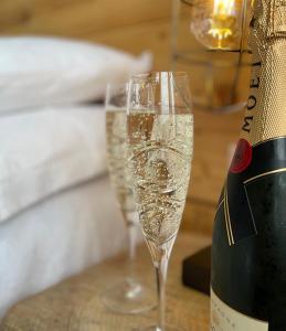 克里基厄斯Môr Heli Guest House Criccieth的桌子旁的两杯香槟酒,旁边是一瓶香槟