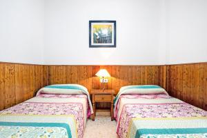 科尼尔-德拉弗龙特拉Apartamento Maribel - Solo Familias的木镶板客房内的两张床