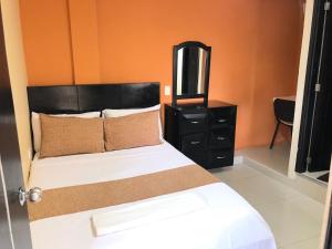 基布多Ayenda Hotel Ecosuite Quibdó的一间卧室配有一张带黑色梳妆台和镜子的床