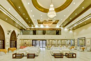 兰奇Treebo Trend Winsome Banquet And Resort的一个带白色椅子和吊灯的大型宴会厅