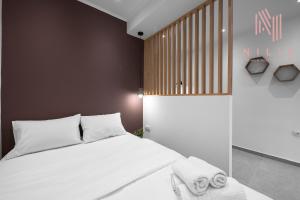 塞萨洛尼基Bourn, Nilie Hospitality MGMT的一间卧室配有带白色床单和毛巾的床。