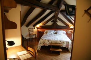 Urdax伊里戈因尼亚乡村酒店的卧室配有一张床铺,位于带横梁的房间内