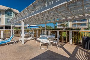 德斯坦200 yds to private gated beach access- 3BR-2BA- quiet location in the heart of Destin!的白色凉棚下带桌椅的天井