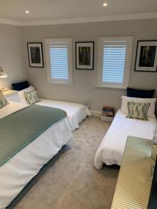 索尔兹伯里Hideaway Holiday Apartment的一间卧室设有两张床和两个窗户。