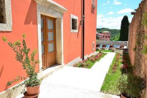 奥普塔利Villa Letizia的橙色的建筑,设有门和庭院