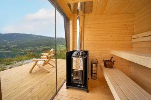 FavangStamp and sauna! Small farm with fantastic view!的木制甲板上的带壁炉的桑拿浴室