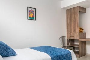 瓦哈卡市JUUB More Oaxaca Impossible (R1)的一间卧室配有一张带蓝毯的床和一张书桌
