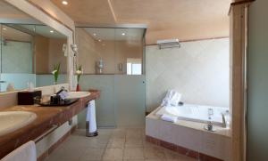 EsteponaSenator Banus的浴室配有2个盥洗盆、浴缸和淋浴。