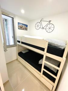 拉格朗德默特Grand studio en centre ville et à 50 mètres du port, climatisé的卧室配有双层床,墙上挂有自行车