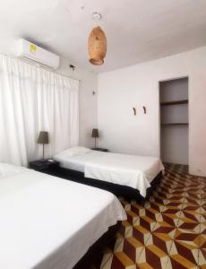 科韦尼亚斯Casa el Muelle的白色墙壁客房的两张床