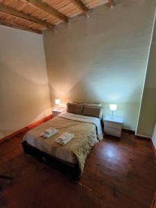 乌斯怀亚Las Violetas的一间卧室配有一张带两盏灯的床。
