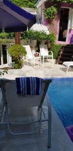 阿雷格里港Morada das Flôres的游泳池旁配有桌椅和遮阳伞