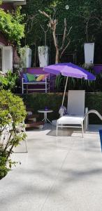 阿雷格里港Morada das Flôres的紫色雨伞、椅子和桌子