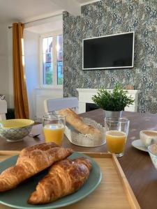 奥贝奈Le Carrousel - Appartement cosy centre Obernai的一张桌子,上面有两根面包和两杯橙汁