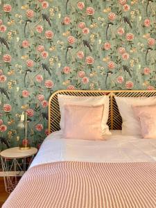 奥贝奈Le Carrousel - Appartement cosy centre Obernai的一间卧室配有一张带花卉壁纸的床
