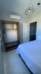 桑托斯Apartamento Frente ao Mar Santos II的卧室配有白色的床和衣柜。