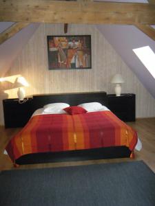 Wambrechies乌巴鲁渡假房屋酒店的一间卧室配有一张带彩色毯子的床