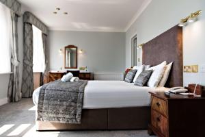 伊斯特布恩The Lansdowne, Eastbourne的一间卧室配有一张大床和木制床头板