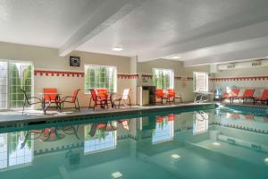 奇黑利斯公园广场套房贝斯特韦斯特优质酒店的一个带红色椅子和红色桌子的游泳池
