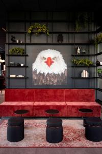 奥斯陆Radisson RED Oslo Økern的一张红色的沙发,里面画着猫头鹰的画
