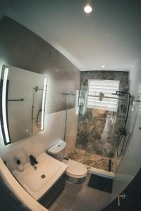 圣胡安SOKZO Miramar的带淋浴、卫生间和盥洗盆的浴室