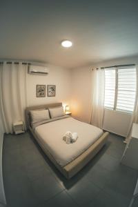 圣胡安SOKZO Miramar的卧室配有一张带白色床单的大床和窗户。