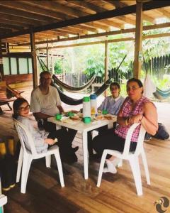 Puerto NariñoHotel Lomas del Paiyü的一群人坐在一张白桌子周围