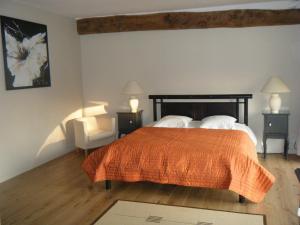 Wambrechies乌巴鲁渡假房屋酒店的一间卧室配有一张床、两盏灯和一把椅子