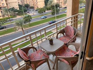 开罗Beautiful appartement. In Cairo Madinaty的阳台配有桌椅,享有街道的景色。