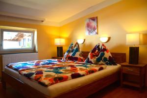 滨湖采尔米兰旅馆的一间卧室配有一张带五颜六色棉被的床