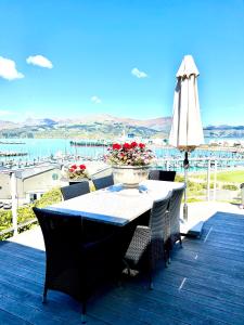  LytteltonSea views in luxury at LYTTELTON BOATIQUE HOUSE - 14 km from Christchurch的甲板上的桌椅和遮阳伞