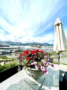  LytteltonSea views in luxury at LYTTELTON BOATIQUE HOUSE - 14 km from Christchurch的花瓶,坐在桌子上,带雨伞