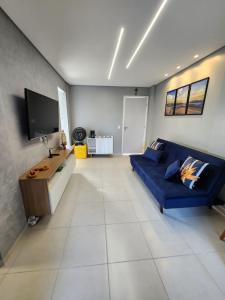 普拉亚弗朗西丝Apartamento na Praia do Francês的客厅配有蓝色的沙发和电视