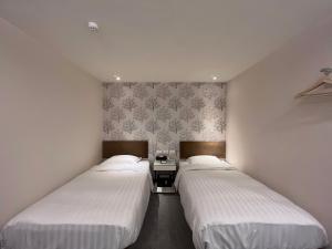 台北璞涟商旅的白色墙壁客房的两张床