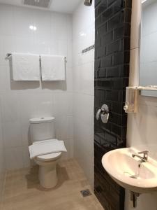 棉兰Odua Golden Mansyur Medan的白色的浴室设有卫生间和水槽。