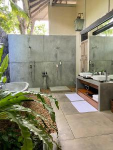 希克杜沃Haritha Villas & Spa的浴室配有两个盥洗盆和浴缸。