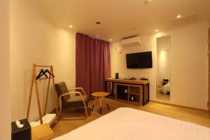 高阳市Hotel Violet的酒店客房配有一张床和一张书桌及一台电视