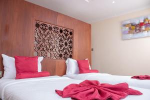 纳库鲁Lake Elementaita Mountain Lodge的两张位于酒店客房的床,上面有红色枕头