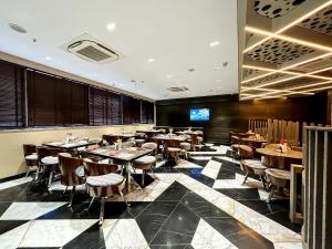 加尔各答Morvee Hotels Alipore Kolkata的一间在房间内配有桌椅的餐厅