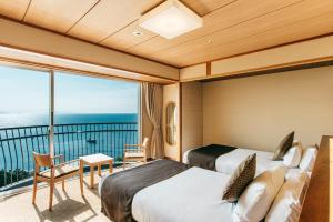 北九州KAMENOI HOTEL Genkainada的酒店客房设有两张床和一个阳台。