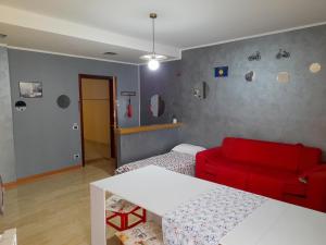塞里亚泰BIKE HOUSE 2 "evo"的客厅配有红色的沙发和床。