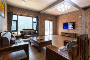 宜昌悠然江景客栈的客厅配有家具和平面电视。