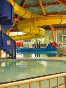 南塞尔尼Willow View - Hoburne Cotswolds Holiday Park的大楼内一个带滑梯的游泳池